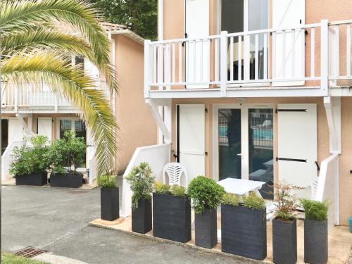 a house with a white chair and some plants at RESIDENCE LA CROISIERE- Appt Duplex 6 Personnes in Anglet