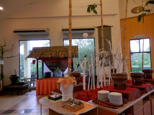 a room with a table with plates and utensils at Hotel Felda Residence Tekam , PPP Tun Razak in Kampong Sungai Batu