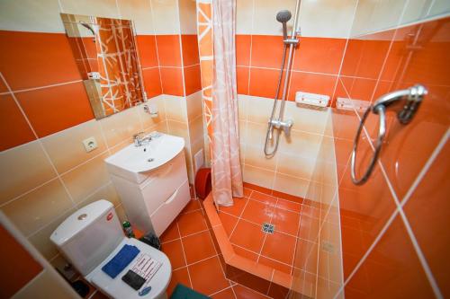 a bathroom with a shower and a toilet and a sink at More Solntsa Guest House in Vityazevo