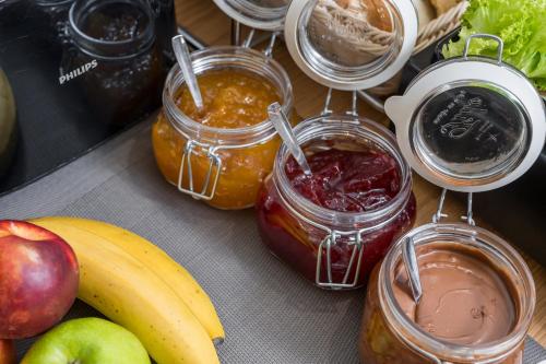 a table with jars of jam next to fruits and vegetables at Casa D'Irene Deluxe Hotel in Falasarna