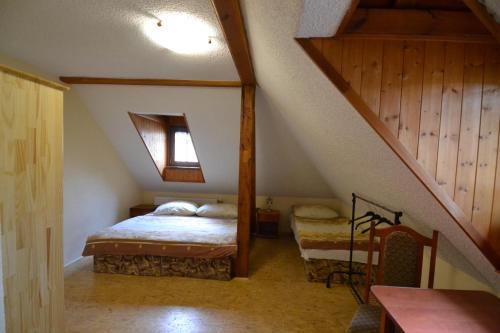 a attic room with a bed and a staircase at Penzion "U Krkovičky" in Brtníky