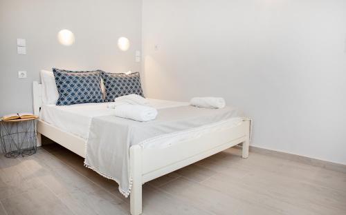 a white bed with two towels on top of it at Grozos Rooms in Parikia