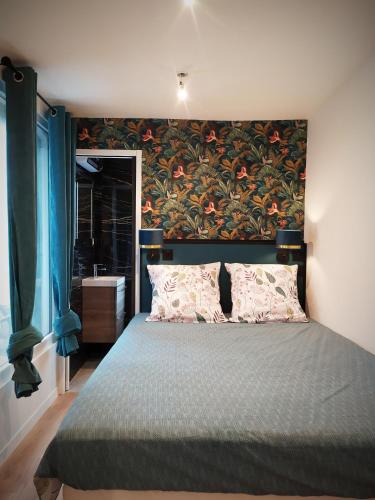- une chambre avec un grand lit et un mur fleuri dans l'établissement PARADISE sur Mer, Terrasse, Spa,Proximité Nausicaa, Plage, Restaurants, à Boulogne-sur-Mer