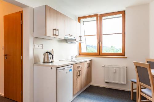 a small kitchen with a white refrigerator and a window at Apartmány Summit in Bešeňová