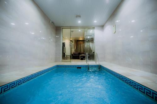 a large swimming pool with blue water in a room at Layali Rahaf Chalets in Abha