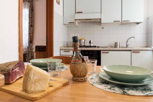 a wooden table with two plates and a bottle of wine at Casa Letizia in Ponsacco