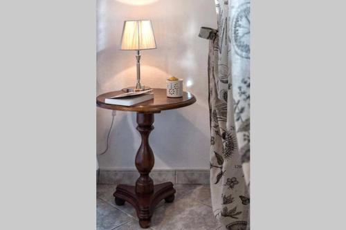 a table with a lamp and a laptop on it at Casa Letizia in Ponsacco