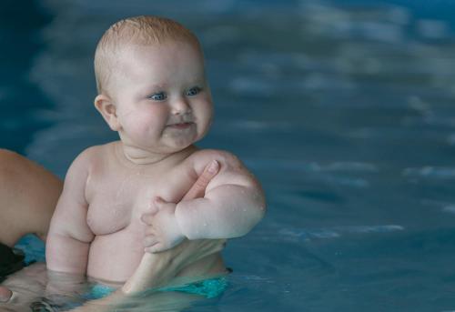 a baby in the water in a swimming pool at 360 Hotel & Thermal Baths in Selfoss