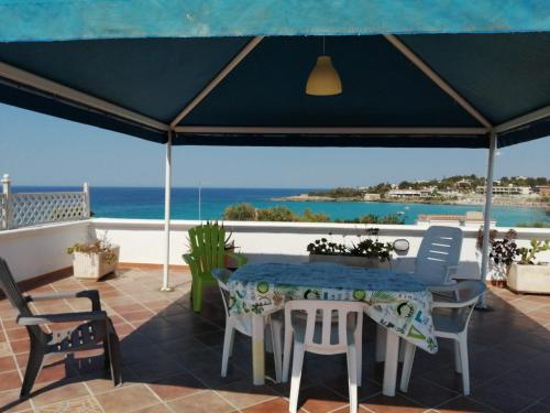 un patio con tavolo, sedie e vista sull'oceano di Montedarena SILVER - A due passi dal mare a Pulsano