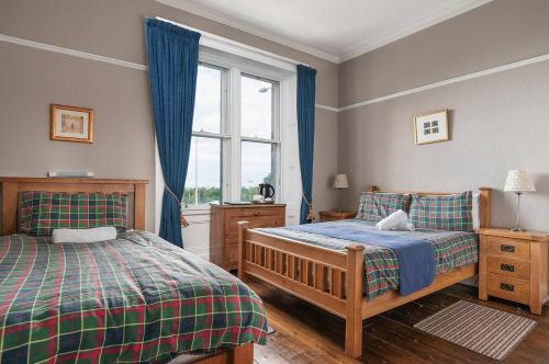um quarto com 2 camas e uma janela em Aynetree Guest House em Edimburgo