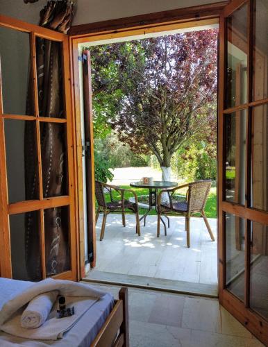 an open door to a patio with a table and chairs at Filoxenia Apartments in Riza