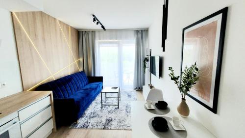- un salon avec un canapé bleu et une table dans l'établissement Apartament SONIA SAUNA-TARGI-GARAŻ, à Kielce