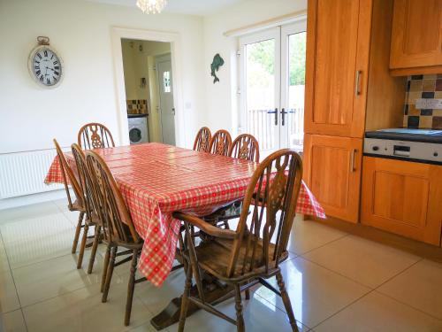 a kitchen with a table with a red checkered table cloth at Holiday Cottages Portsalon in Portsalon