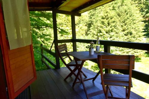 eine Veranda mit einem Tisch und 2 Stühlen auf einer Terrasse in der Unterkunft Sommerhaus Bella Vita in Bad Schandau