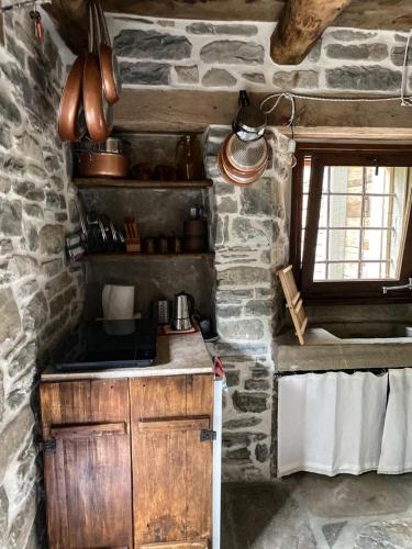 a stone kitchen with a sink and a stove at Casina del Ponte in Bagno di Romagna