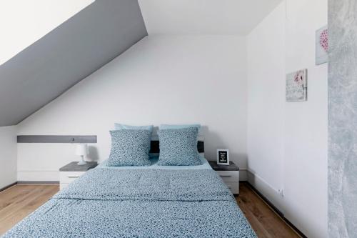 1 dormitorio con 1 cama grande con almohadas azules en Comfort Stay Basel Airport 3B46, en Saint-Louis