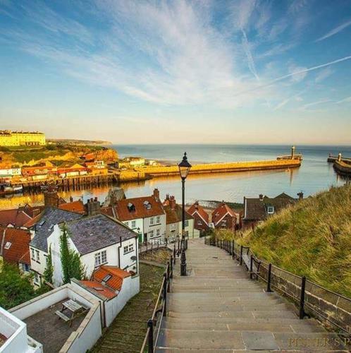 a walkway next to a body of water with a pier at Cottages-Whitby in Whitby