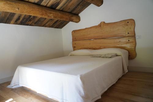 a bed in a room with wooden ceilings at Casina del Ponte in Bagno di Romagna