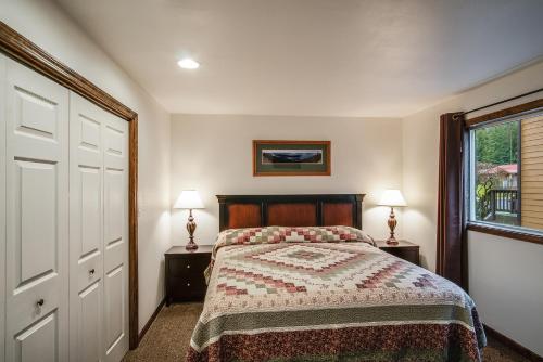 a bedroom with a bed and a window and two lamps at Pend Oreille Shores Resort in Hope
