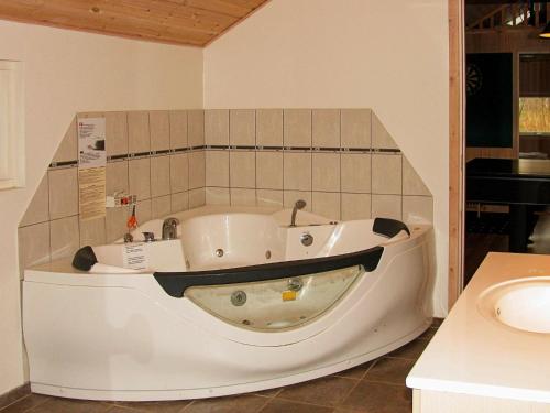 a bath tub in a room with a sink at Holiday home Idestrup III in Marielyst