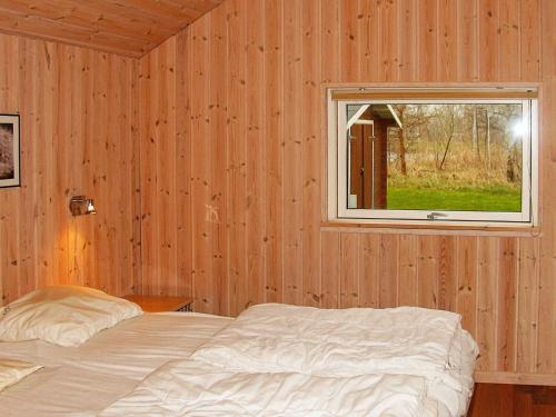 a bedroom with a bed and a window at Holiday home Idestrup III in Marielyst