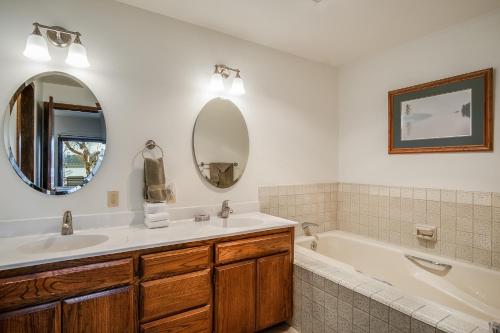 a bathroom with a sink and a tub and a mirror at Pend Oreille Shores Resort in Hope