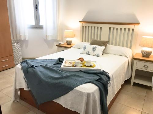 a bedroom with a bed with a tray of food on it at Citybeach - parking & wifi in Las Palmas de Gran Canaria