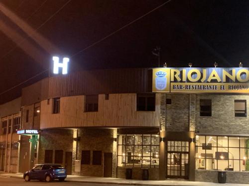 a building with a sign on top of it at night at Hotel Riojano in Humanes de Madrid