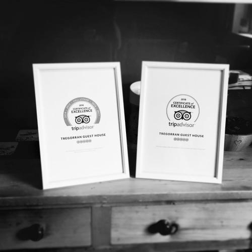 two white signs sitting on top of a table at Tregorran Guest House Mevagissey in Mevagissey