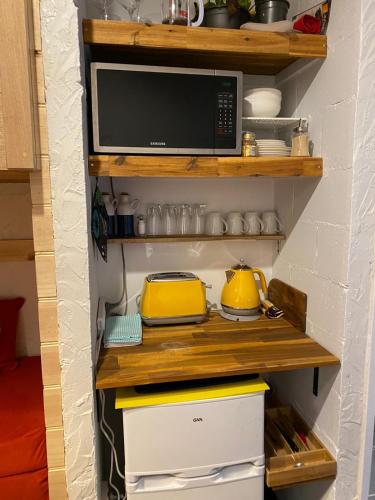 a kitchen with a microwave on a shelf at Cosy Apartment Tara Edelweiss at Skiing Resort of Falls Creek in Falls Creek