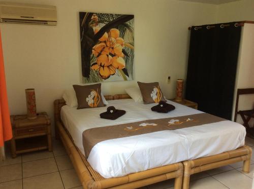 Un dormitorio con una cama con dos sombreros. en Relais Fenua, en Punaauia
