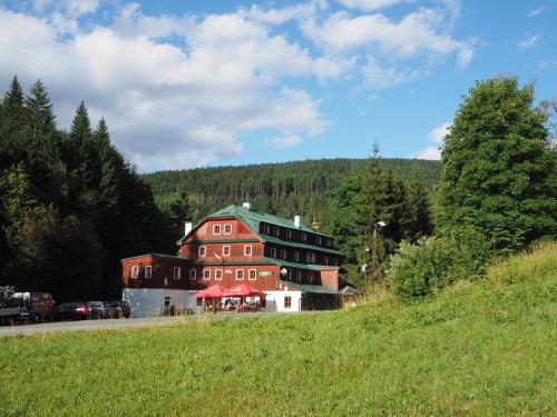 a large red building with a green roof on a hill at Hotel Alba in Deštné v Orlických horách