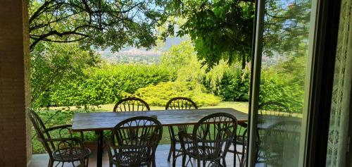 una mesa de madera con 4 sillas y una ventana en Agriturismo Tognoloni, en Gubbio
