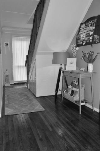 a living room with a staircase and a table at Tregorran Guest House Mevagissey in Mevagissey