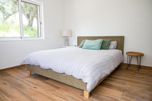 a bed in a white room with a window at Monte da Cegonha Preta in Montargil