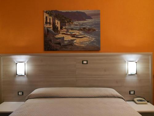 マッサにあるHotel Annunziataのベッドルーム1室(壁に絵画が描かれたベッド1台付)