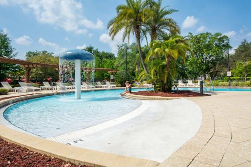 a swimming pool in a resort with a palm tree at HAPPY PORT, your home very close to entertainment in Kissimmee