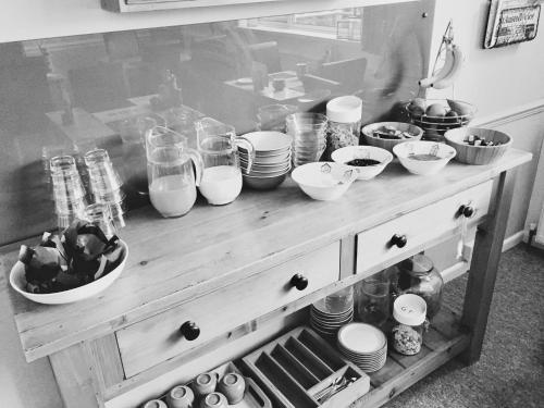 a table with many bowls and plates on it at Tregorran Guest House Mevagissey in Mevagissey