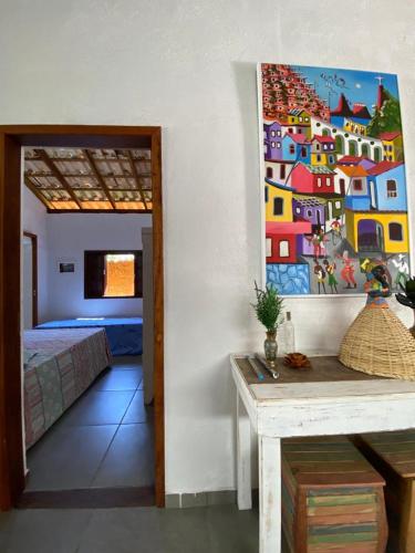 a room with a bed and a painting on the wall at BEM ESTAR À BEIRA MAR in Ubatuba