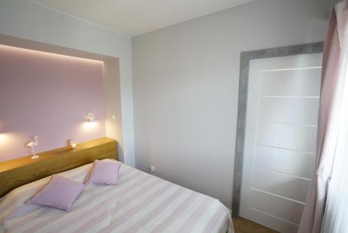 a bedroom with a bed with purple pillows and a closet at Apartament na Wspólnej ( centrum, garaż ) in Kielce