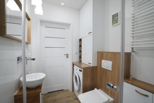 a bathroom with a sink and a washing machine at Apartament na Wspólnej ( centrum, garaż ) in Kielce