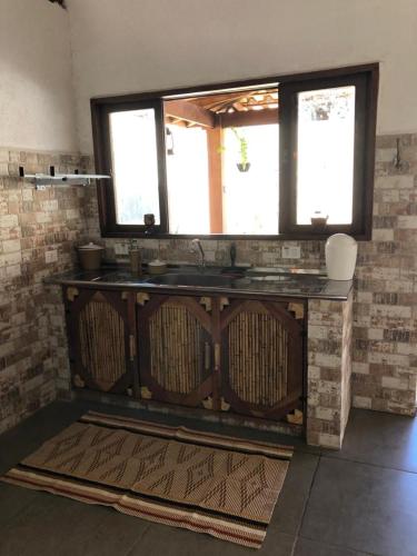 a kitchen with a counter and two windows at BEM ESTAR À BEIRA MAR in Ubatuba