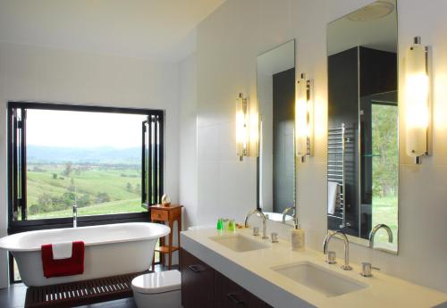 a bathroom with a tub and two sinks and a window at The Ridge Gloucester in Gloucester
