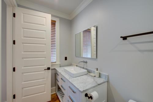 a white bathroom with a sink and a mirror at The Quarters on King in Charleston