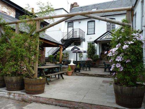 um pátio exterior com uma mesa de piquenique e um edifício em The Falcon Hotel em Bromyard