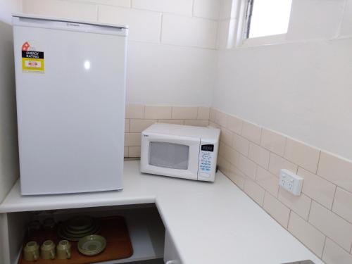a microwave sitting on a counter in a kitchen at Millicent Motel in Millicent