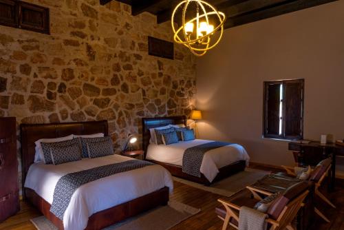 1 dormitorio con 2 camas y lámpara de araña en Hacienda Tovares, en Cadereyta de Montes