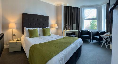 a hotel room with a large bed and a chair at The Park Hotel in Tenby