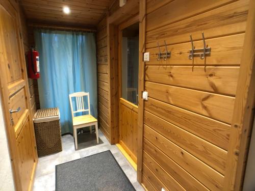 a wooden room with a wooden door and a chair at Harmaalokki in Savonlinna