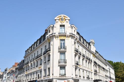 a white building with a clock on the top of it at Le Grand Hotel in Tours
